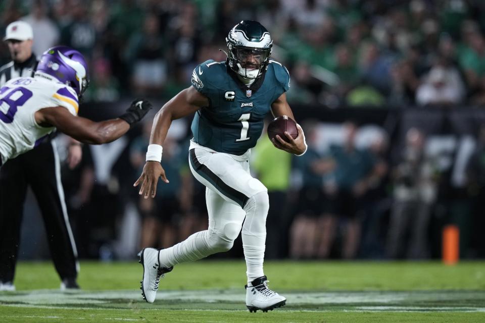 Philadelphia Eagles quarterback Jalen Hurts (1) runs with the ball past Minnesota Vikings linebacker Jordan Hicks during the first half of an NFL football game Thursday, Sept. 14, 2023, in Philadelphia. (AP Photo/Matt Slocum)