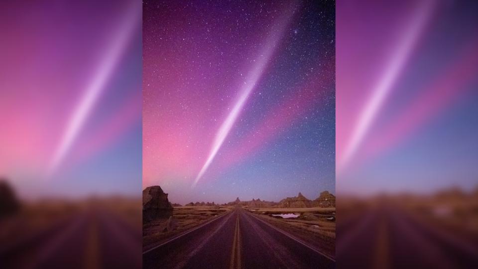  A pink streak shines in the sky above Badlands National Park. 