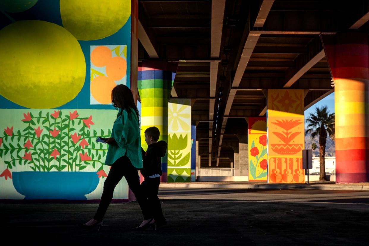 Alex Sanchez and her son Shahar Sanchez, 5, of Indio walk amongst the murals under downtown Indio's Jackson Street Bridge following the unveiling event with the artists Wednesday.