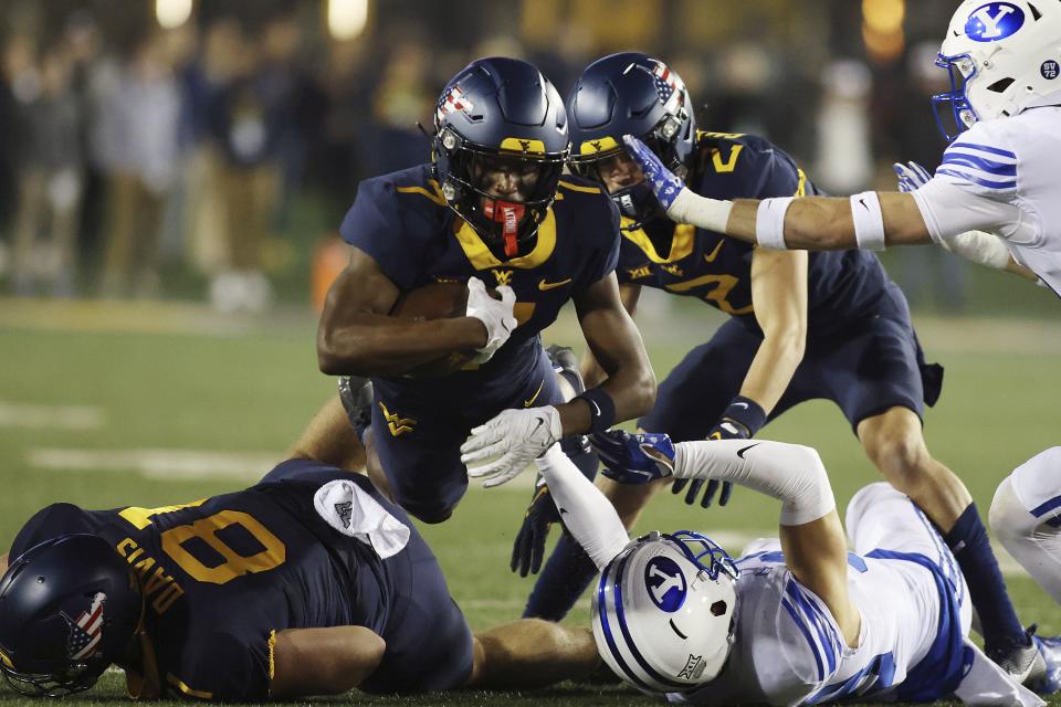 West Virginia’s Traylon Ray, top, jumps over players during the first half of an NCAA college football game against BYU on Saturday, Nov. 4, 2023, in Morgantown, W.Va. | Chris Jackson, Associated Press