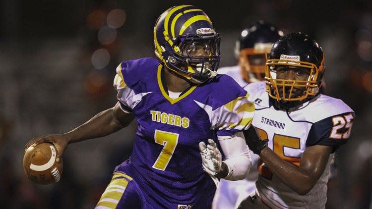 Boyton Beach quarterback Lamar Jackson scrambles while being pursued by Fort Lauderdale-Stranahan’s Cleveland Singletary during the Tigers’ 54-27 victory Friday night in Boynton. Jackson ran for two touchdowns and threw for another. (Damon Higgins / The Palm Beach Post)