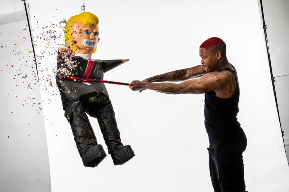 A man hits a piñata of Donald Trump; candy flies out
