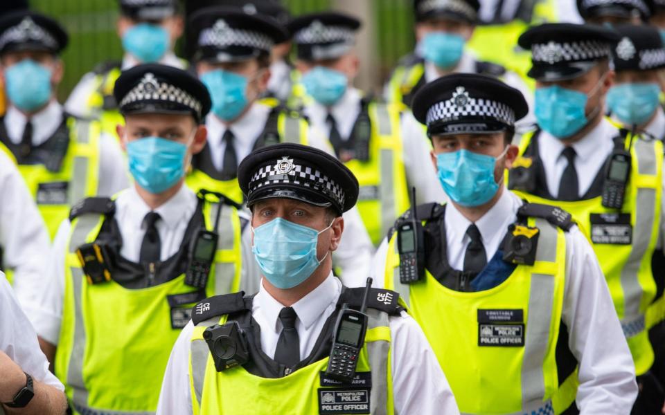 Police wearing protective face masks at an Extinction Rebellion protest in Parliament Square, London -  Dominic Lipinski /PA
