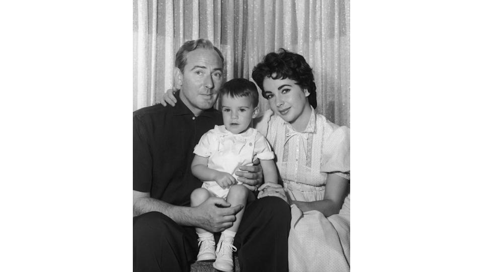 Black-and-white photo of Michael Wilding and Elizabeth Taylor holding a baby boy