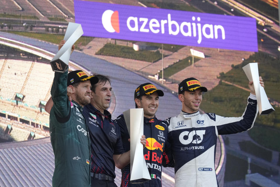 First place, Red Bull driver Sergio Perez of Mexico, second right, stands on the podium with second place, Aston Martin driver Sebastian Vettel of Germany, left, and third place, AlphaTauri driver Pierre Gasly of France, right, during the Formula One Grand Prix at the Baku Formula One city circuit in Baku, Azerbaijan, Sunday, June 6, 2021. (AP Photo/Darko Vojinovic)