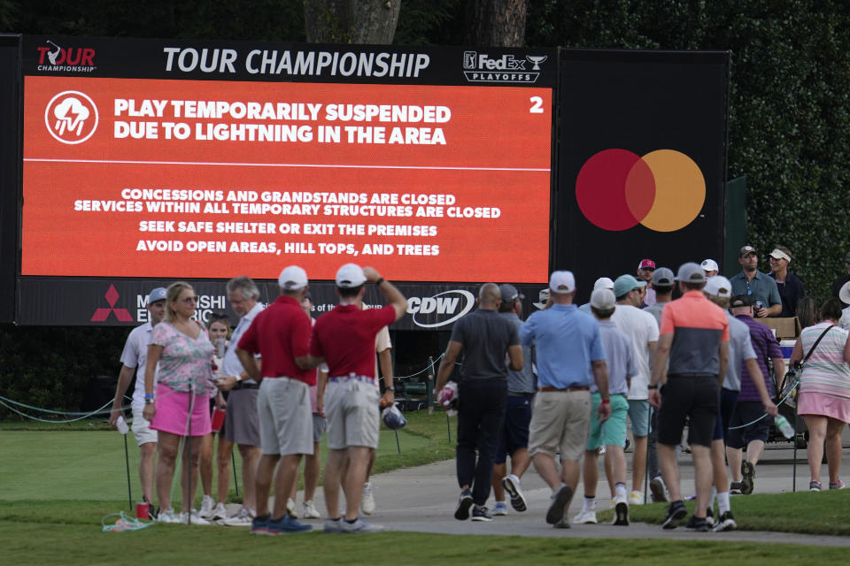 Golf fans leave the course after play was suspended due to weather during the third round of the Tour Championship golf tournament at East Lake Golf Club Saturday, Aug. 27, 2022, in Atlanta. (AP Photo/Steve Helber)