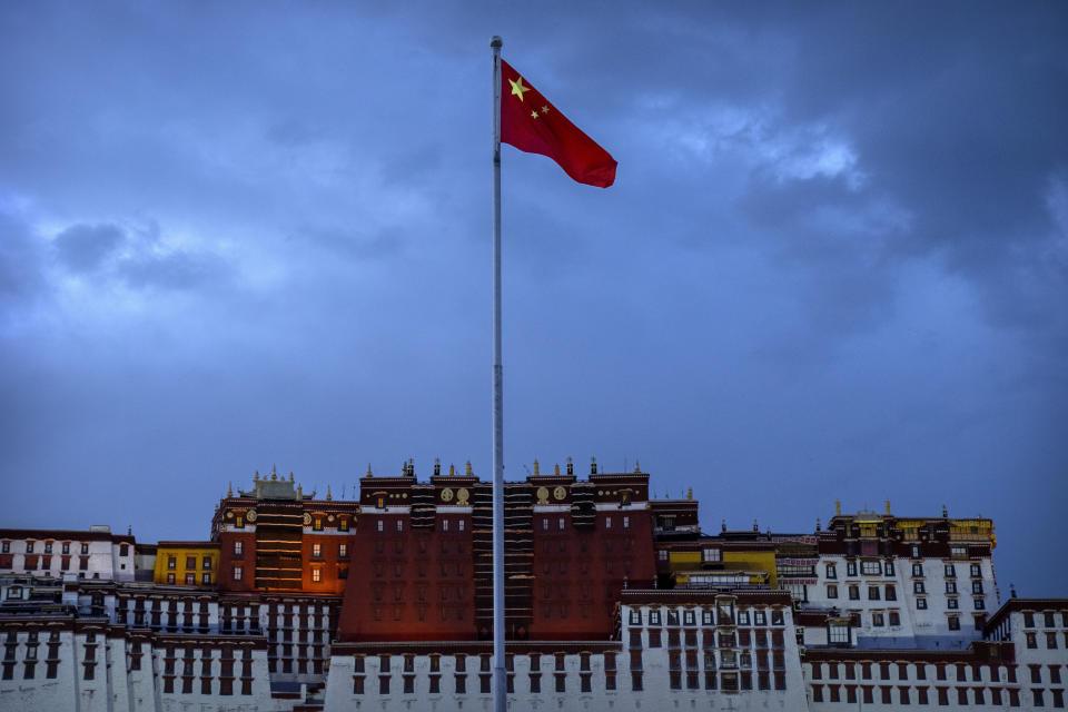 The Chinese flag flies at a plaza near the Potala Palace in Lhasa in western China's Tibet Autonomous Region, Tuesday, June 1, 2021, as seen during a government organized visit for foreign journalists. High-pressure tactics employed by China's ruling Communist Party appear to be finding success in separating Tibetans from their traditional Buddhist culture and the influence of the Dalai Lama. (AP Photo/Mark Schiefelbein)