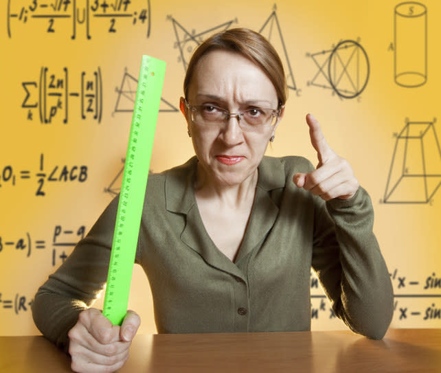 A teacher holding a ruler and pointing her finger