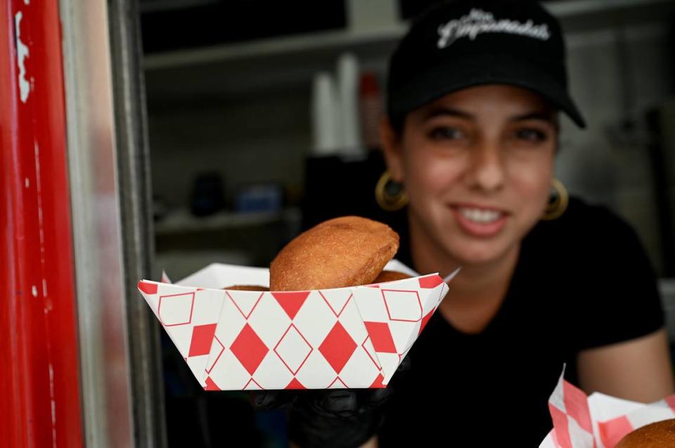 Claudia Risandra Padrón serves up empanadas at the Miss Empanada food truck behind the former Miller’s Dutch Kitchen on 14th Street on Tuesday, Oct. 3, 2023.