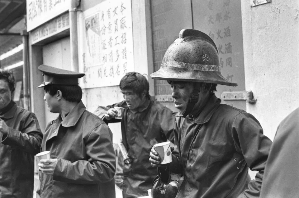 1979 年 1 月 31 日，鰂魚涌長華工業大廈一間塑膠廠發生火警，消防處奉召灌救，入過火場的消防員都被燻黑，暫時要抖一抖。 (Photo by Chan Kiu/South China Morning Post via Getty Images)