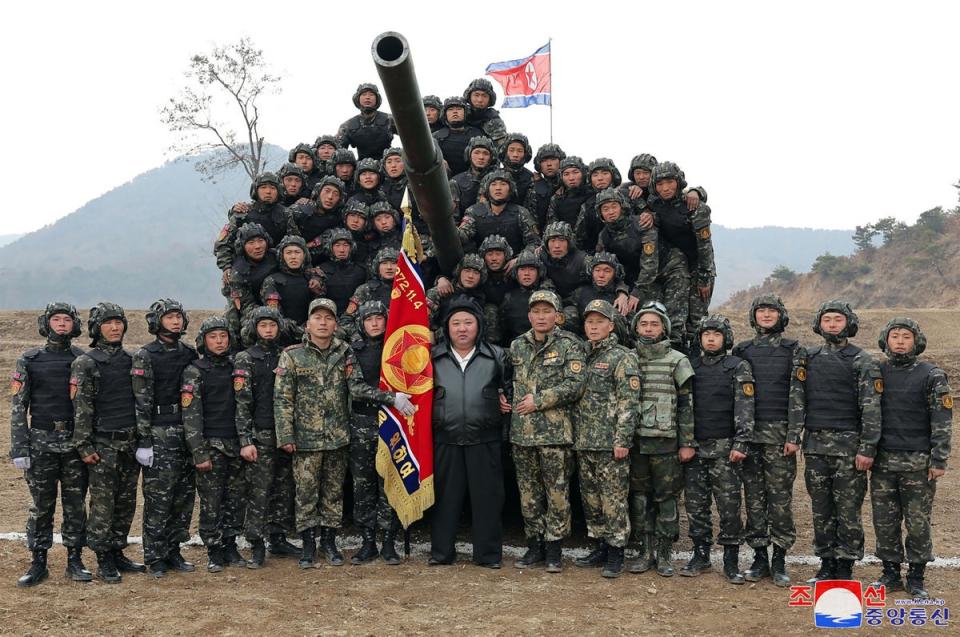 North Korean leader Kim Jong Un (C) posing with personnel during a training competition between the combined forces of the Korean People’s Army tank crews at an undisclosed location in North Korea (KCNA VIA KNS/AFP via Getty Image)