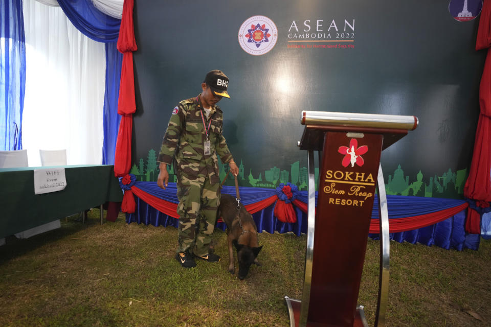 A security person takes a dog for sniffing at the media center near the venue for the upcoming Association of Southeast Asian Nations (ASEAN) Defense Ministers' Meeting (ADMM) in Siem Reap, Cambodia, Tuesday, Nov. 22, 2022. (AP Photo/Heng Sinith)