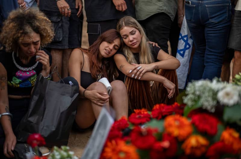 Relatives and friends attend the funeral of Shani Luk, a 22-year-old German-Israeli who was killed while fleeing a music festival on October 7th. The Israel Defense Forces (IDF) had said on Friday that it had recovered three bodies of hostages, including that of the German-Israeli Shani Louk. Ilia Yefimovich/dpa