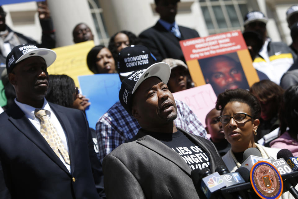 Derrick Hamilton, center, speaks as he and a group of other New York City men, who claim they were framed by a crooked police detective decades ago, voice their demand for prosecutors to speed up an ongoing review of the detective's cases at a rally on the steps of City Hall, Wednesday, April 9, 2014, in New York. They claim they were convicted on evidence fabricated by the now-retired detective, Louis Scarcella. (AP Photo/Jason DeCrow)