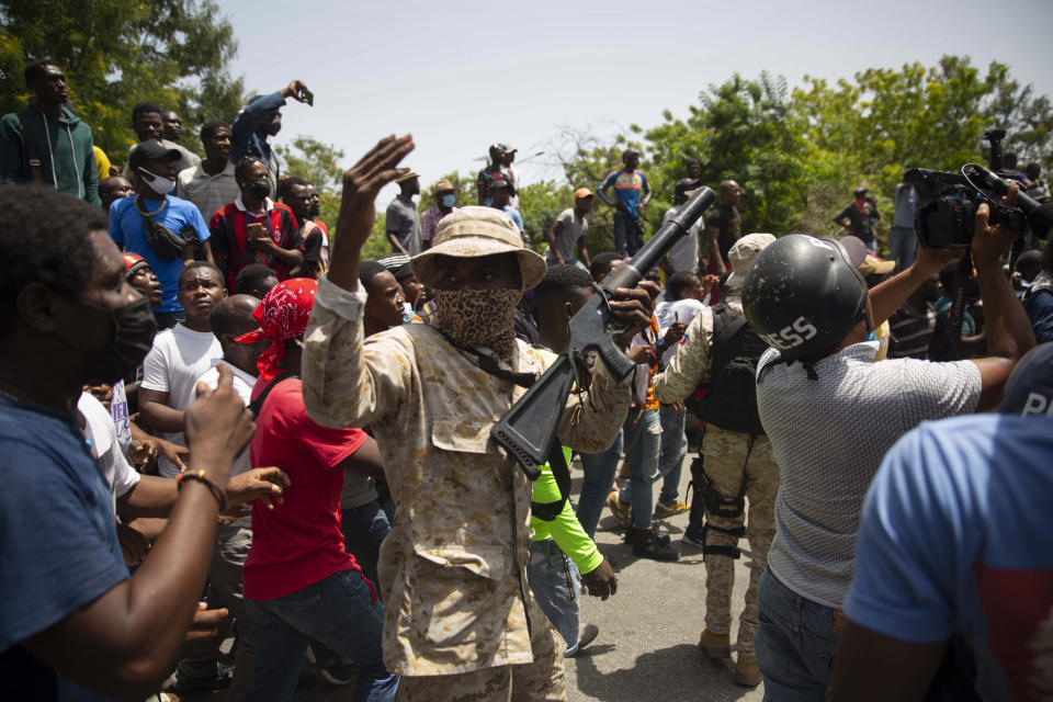 Police stand amid a crowd protesting against the assassination of Haitian President Jovenel Moïse near the police station of Petion Ville in Port-au-Prince, Haiti, Thursday, July 8, 2021. Officials pledged to find all those responsible for the pre-dawn raid on Moïse’s home early Wednesday in which the president was shot to death and his wife, Martine, critically wounded. (AP Photo/Joseph Odelyn)