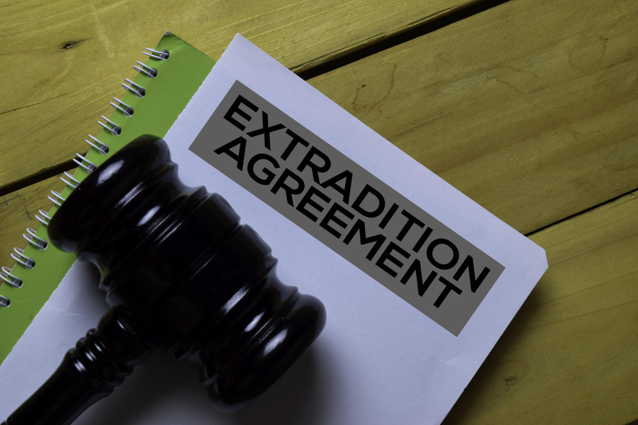 Extradition Agreement document and a judge's gavel on wooden desk. (Photo: Getty)