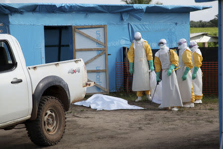 Health workers, wearing head-to-toe protective gear, prepare for work outside an isolation unit in Foya District, Lofa County, Liberia in this July 2014 UNICEF handout photo. REUTERS/Ahmed Jallanzo/UNICEF/Handout via Reuters