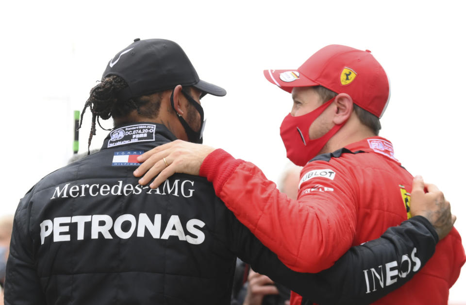 Mercedes driver Lewis Hamilton of Britain, left, speaks with third placed Ferrari driver Sebastian Vettel of Germany after winning the Turkish Formula One Grand Prix at the Istanbul Park circuit racetrack in Istanbul, Sunday, Nov. 15, 2020. (Clive Mason/Pool via AP)