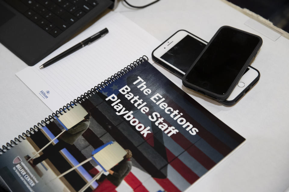 In this Monday, Dec. 16, 2019, photo, the Battle Staff Playbook is seen on the table during an exercise run by military and national security officials, for state and local election officials to simulate different scenarios for the 2020 elections, Monday, Dec. 16, 2019, in Springfield, Va. These government officials are on the front lines of a different kind of high-stakes battlefield, one in which they are helping to defend American democracy by ensuring free and fair elections. (AP Photo/Alex Brandon)