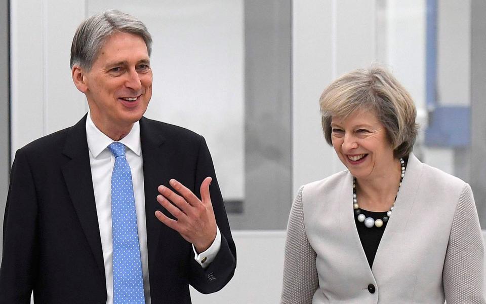Former prime minister Theresa May and her chancellor, Philip Hammond, tour a Renishaw plant in November 2016 - TOBY MELVILLE/Reuters