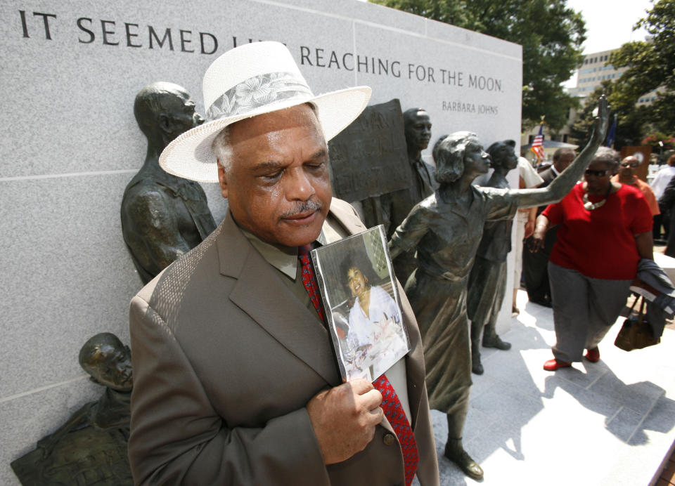 FILE - In this July 21, 2008, file photo, Roderick Johns, brother of Civil Rights activist Barbara Johns, takes a moment as he holds a photo of his sister at the newly dedicated Virginia Civil Rights Memorial on the grounds of the State Capitol in Richmond, Va. There will soon be a statue saluting Virginia’s Barbara Johns, a 16-year-old Black girl who staged a strike in 1951 over unequal conditions at her segregated high school in Farmville. Her actions led to court-ordered integration of public schools across the U.S, via the landmark Supreme Court decision, Brown v. Board of Education. (AP Photo/Steve Helber, File)