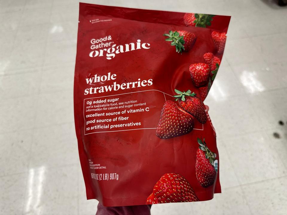 hand holding up a big bag of frozen organic strawberries at target