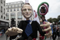 A puppet shows French President Emmanuel Macron holding photos, right, of far-right leader Marine Le Pen is pictured during a demonstration, Saturday, June 12, 2021 in Paris. Thousands of people rallied throughout France Saturday to protest against the far-right. (AP Photo/Lewis Joly)