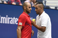 Nick Kyrgios, of Australia, right, talks with doubles partner Marius Copil, of Romania, during a first round match against Ken Skupski, of the United Kingdom, and Marcus Daniell, of New Zealand, during the US Open tennis championships Friday, Aug. 30, 2019, in New York. (AP Photo/Sarah Stier)