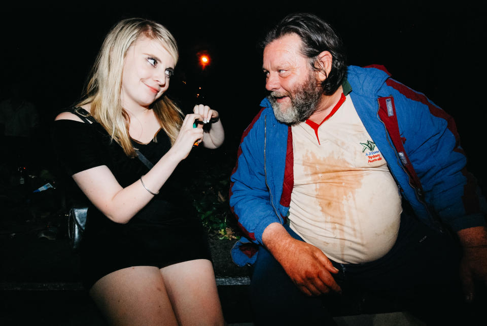 A young girl smiles at a homeless man. 