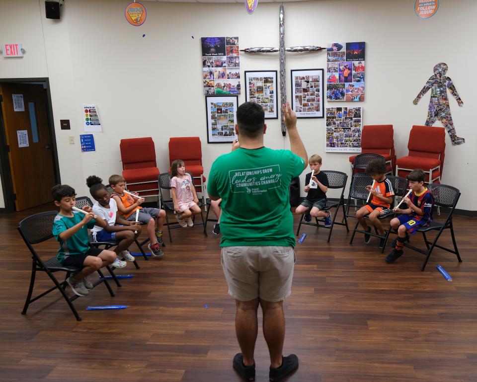 Sergio Vasquez, Project Transformation young adult leader, teaches children to play recorders during a Young Artists session at the summer literacy day camp at  New Hope United Methodist Church.