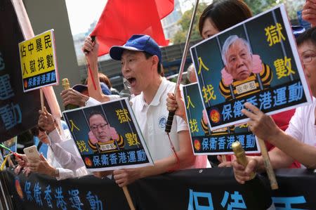 Pro-China supporters hold a Chinese national flag and a picture of Occupy Central founders Benny Tai and Chu Yiu-ming, outside the court in Hong Kong, China April 9, 2019. REUTERS/Tyrone Siu