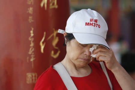 Wang Run Xiang, 58, the mother of a passenger aboard missing Malaysia Airlines flight MH370, wipes her eyes at the Thean Hou temple in Kuala Lumpur, March 1, 2015. REUTERS/Olivia Harris