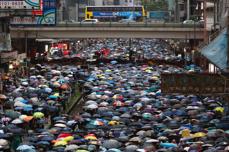 Demonstrators carry umbrellas as they march along a street in Hong Kong, Sunday, Aug. 18, 2019. Heavy rain fell on tens of thousands of umbrella-ready protesters as they started marching from a packed park in central Hong Kong, where mass pro-democracy demonstrations have become a regular weekend activity. (AP Photo/Vincent Yu)