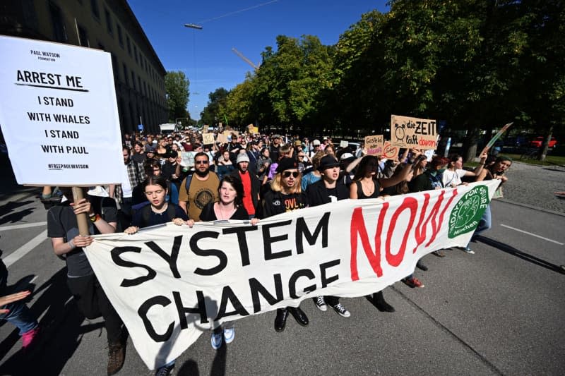 People holding a banner walk through Arcisstrasse during a demonstration to mark Fridays for Future's global climate strike. Felix Hörhager/dpa