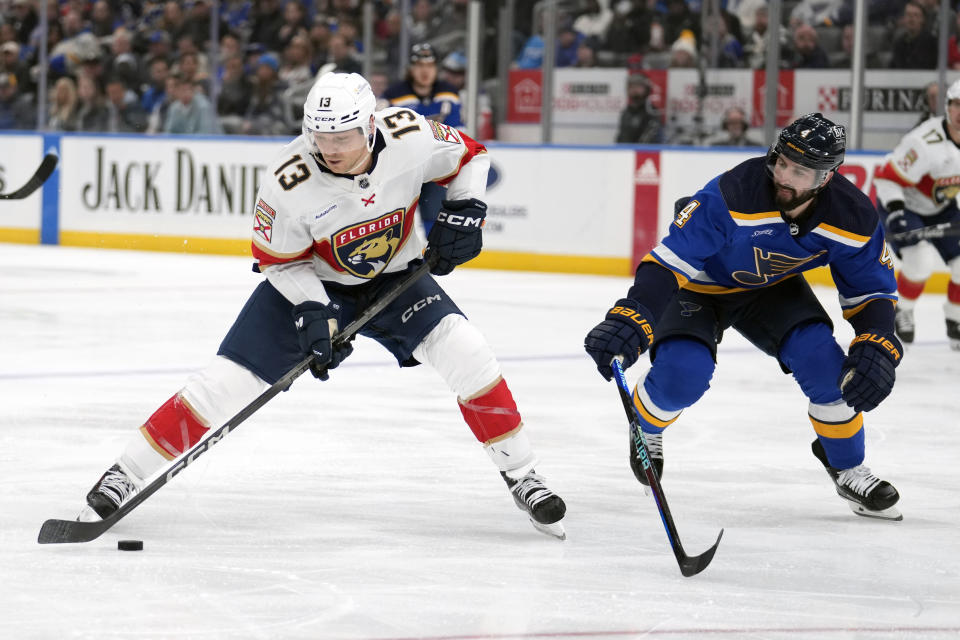 Florida Panthers' Sam Reinhart (13) handles the puck as St. Louis Blues' Nick Leddy (4) defends during the third period of an NHL hockey game Tuesday, Jan. 9, 2024, in St. Louis. (AP Photo/Jeff Roberson)
