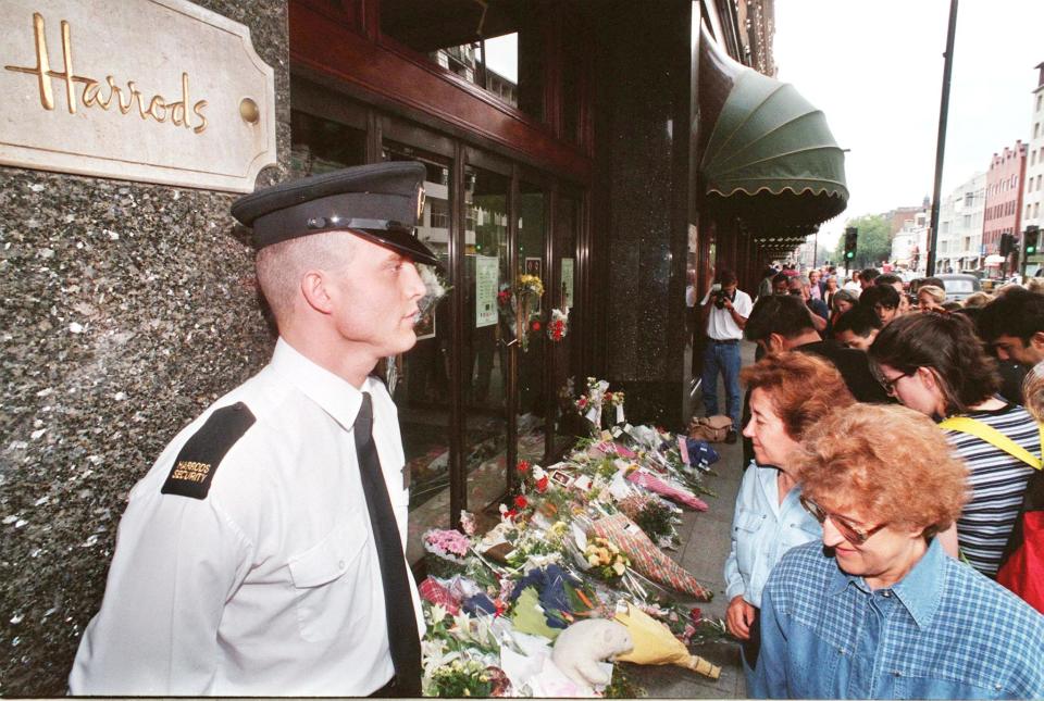 A Harrod's security guard keeps a vigil on floral tributes at Harrod's store in Knightsbrige, London 31 August as a mark of respect after the son of Harrod's owner Muhamed Al-Fayed, Dodi Al-Fayed, died with Diana the Princess of Wales in a Paris traffic accident earlier today. (Photo by PAUL VICENTE / AFP)        (Photo credit should read PAUL VICENTE/AFP via Getty Images)