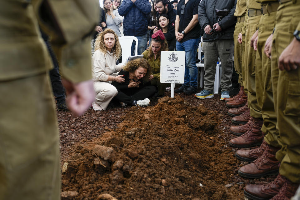 Sivan, mother of Israeli soldier, Sergeant Dolev Malca mourns in grief over his grave during his funeral in Shlomi, northern Israel, on the border with Lebanon, Sunday, March 3, 2024. Malca ,19, was killed during Israel's ground operation in the Gaza Strip, where the Israeli army has been battling Palestinian militants in the war ignited by Hamas' Oct. 7 attack into Israel. (AP Photo/Ariel Schalit)