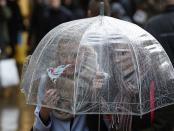 Shoppers walk in wet and windy weather on Oxford Street in central London December 23, 2013. REUTERS/Olivia Harris