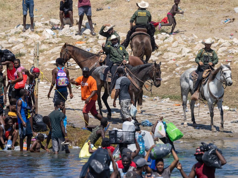 Migrants interact with Border Patrol agents (Getty Images)