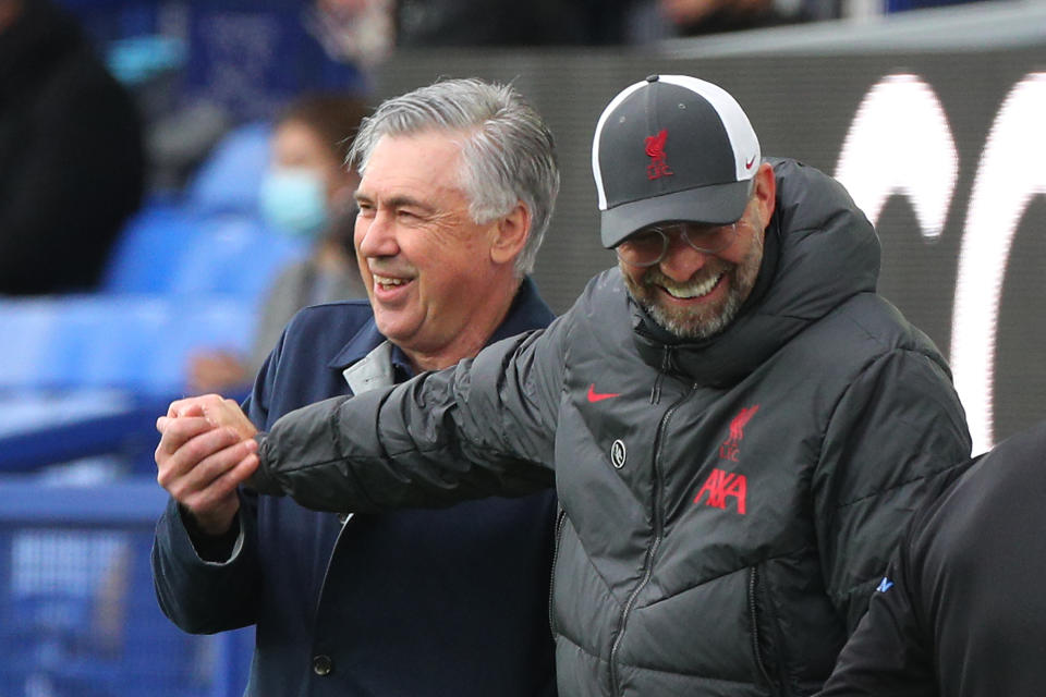 Everton's Italian head coach Carlo Ancelotti (L) and Liverpool's German manager Jurgen Klopp share a light moment during the English Premier League football match between Everton and Liverpool at Goodison Park in Liverpool, north west England on October 17, 2020. (Photo by Peter Byrne / POOL / AFP) / RESTRICTED TO EDITORIAL USE. No use with unauthorized audio, video, data, fixture lists, club/league logos or 'live' services. Online in-match use limited to 120 images. An additional 40 images may be used in extra time. No video emulation. Social media in-match use limited to 120 images. An additional 40 images may be used in extra time. No use in betting publications, games or single club/league/player publications. / (Photo by PETER BYRNE/POOL/AFP via Getty Images)