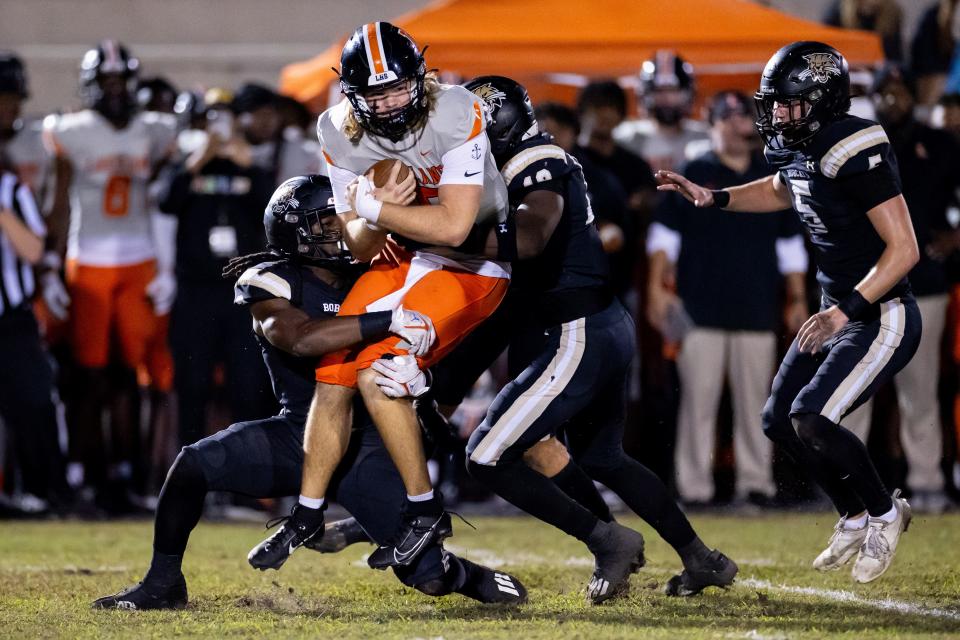 Buchholz Bobcats defensive lineman Jamaryn Reese (19) and Buchholz Bobcats middle linebacker Myles Graham (2) tackle Lakeland Dreadnaughts quarterback Zander Smith (15) during the first half in the Semifinals of the 2023 FHSAA Football State Championships at Citizens Field in Gainesville, FL on Friday, December 1, 2023. [Matt Pendleton/Gainesville Sun]