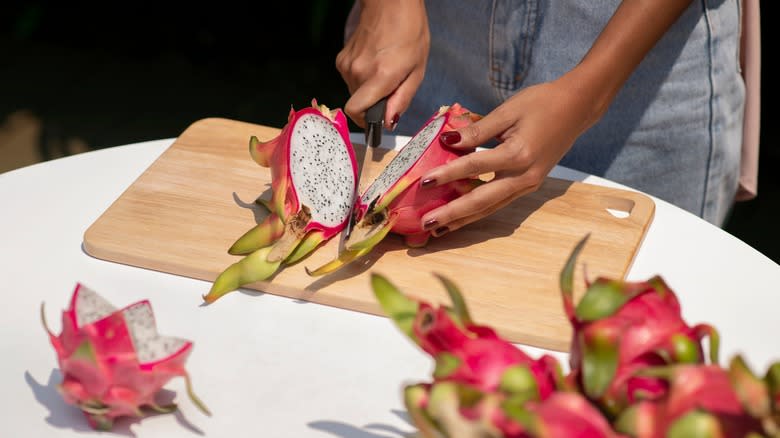 Person slicing a dragon fruit in half