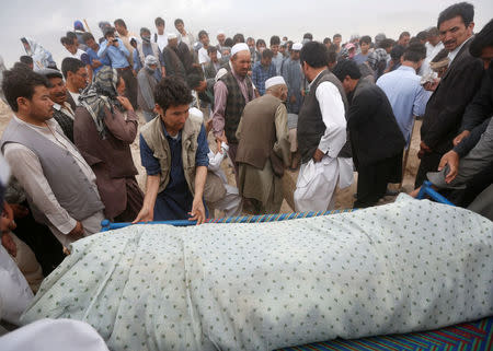 Afghan men carry the body of a victim for the burial ceremony a day after a suicide attack in Kabul, Afghanistan July 24, 2016.REUTERS/Omar Sobhani