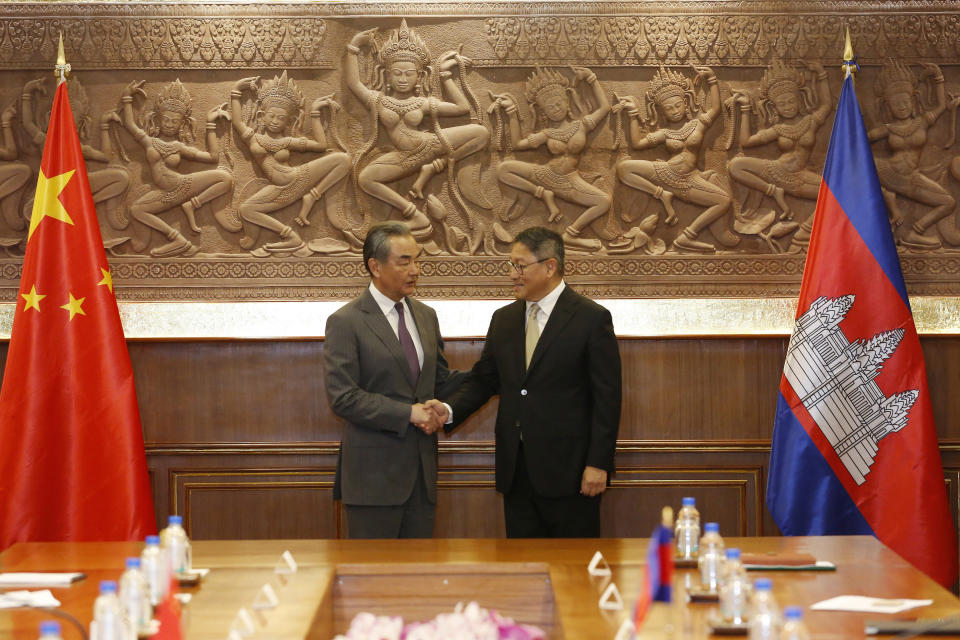 In this photo released by Agence Kampuchea Press (AKP), Chinese Foreign Minister Wang Yi, left, greets with Cambodia's Foreign Minister, SOK Chenda Sophea, right, in Phnom Penh, Cambodia, Sunday, April 21, 2024. Wang Yi, arrived Cambodia to mark his 3 days official visit (21-23 April) Cambodia to reaffirm his country's commitment and to boost the already firmly tied to southeast Asian country, twice visited in the last eight months. (AKP via AP)