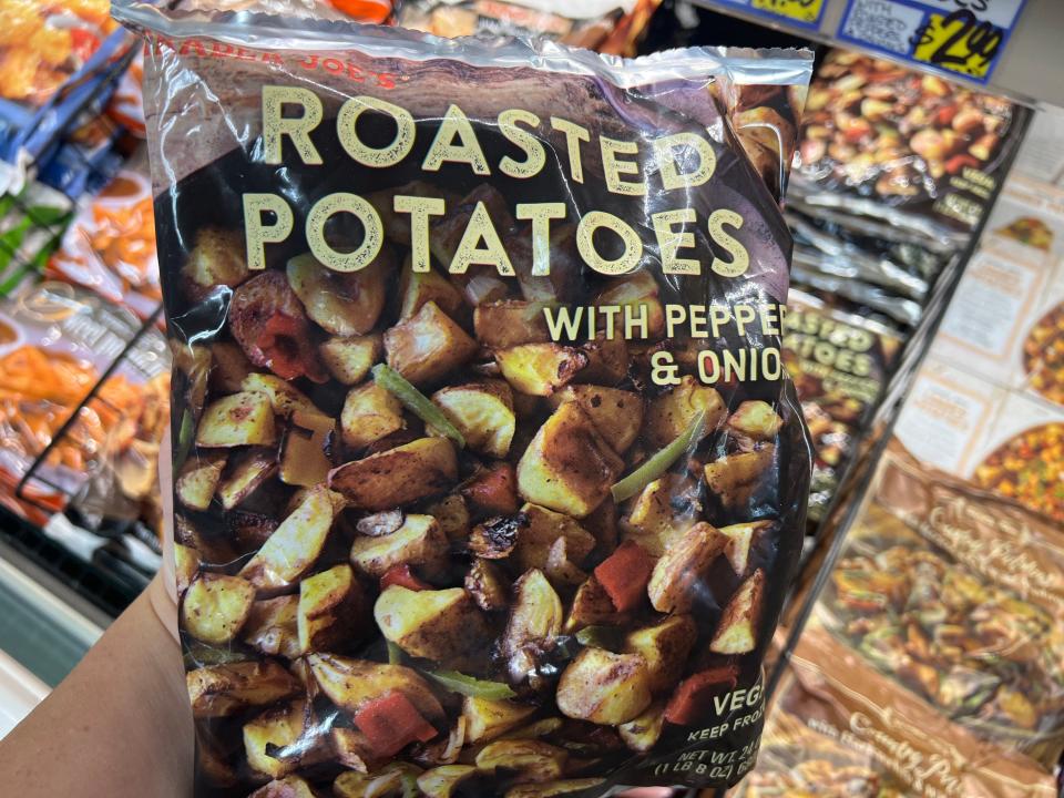 The writer holds a bag of roasted potatoes at Trader Joe's