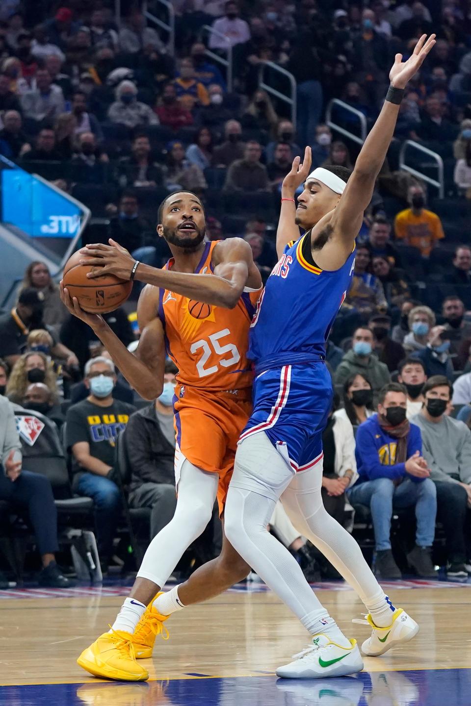 Phoenix Suns forward Mikal Bridges (25) drives against Golden State Warriors guard Jordan Poole during the first half of an NBA basketball game in San Francisco, Friday, Dec. 3, 2021. (AP Photo/Jeff Chiu).