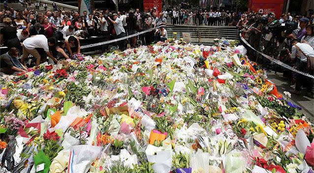 Hundreds of flowers are left as a sign of respect at Martin Place, where nearly 12 hours ago a dark siege situation came to an explosive end. Photo: Mark Metcalfe/Getty Images