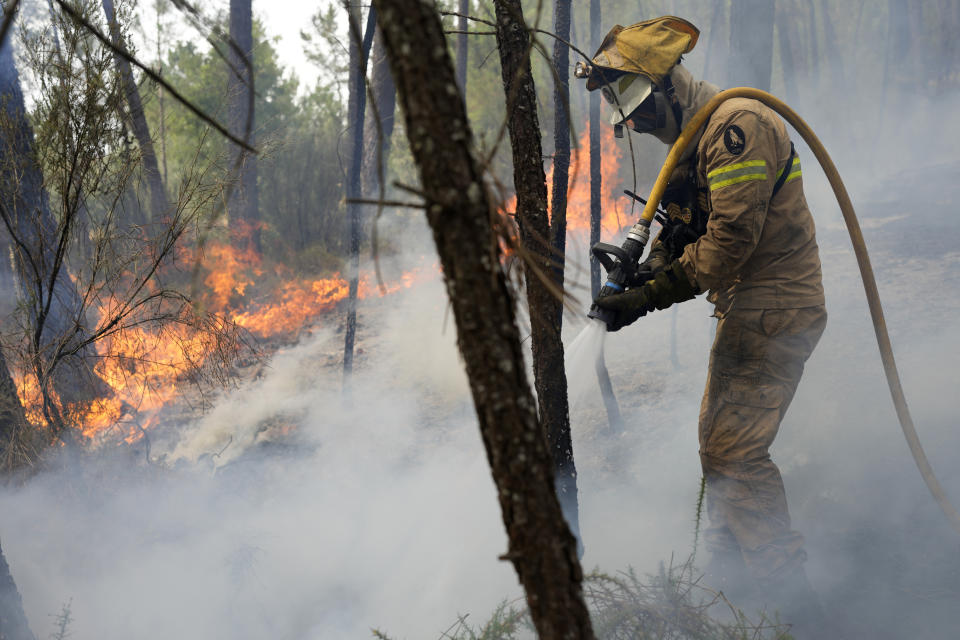 FILE - A National Republican Guard firefighter put out a forest fire in the village of Rebolo, near Ansiao central Portugal, July 14, 2022. Major wildfires in Europe are starting earlier in the year, becoming more frequent, doing more damage and getting harder to stop. And, scientists say, they’re probably going to get worse as climate change intensifies unless countermeasures are taken. (AP Photo/Armando Franca, File)