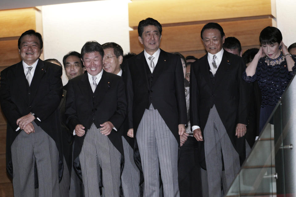 Japanese Prime Minister Shinzo Abe, center, and his new cabinet prepare for a group photo session at the prime minister's official residence in Tokyo Wednesday, Sept. 11, 2019. (AP Photo/Eugene Hoshiko)