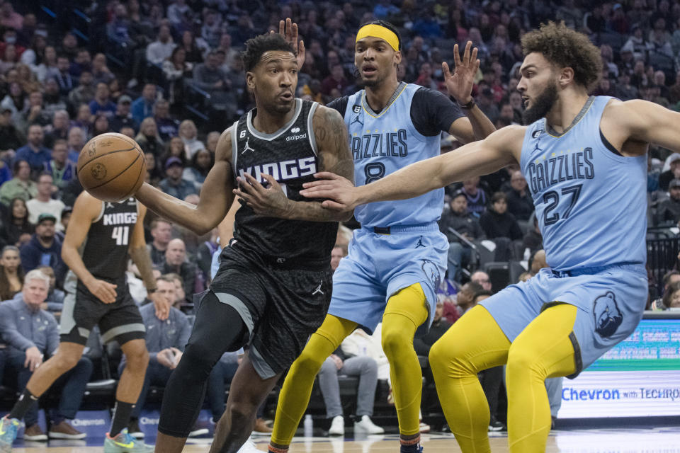 Sacramento Kings guard Malik Monk, left, is guarded by Memphis Grizzlies forward Ziaire Williams (8) and David Roddy (27) during the first quarter of an NBA basketball game in Sacramento, Calif., Monday, Jan. 23, 2023. (AP Photo/Randall Benton)